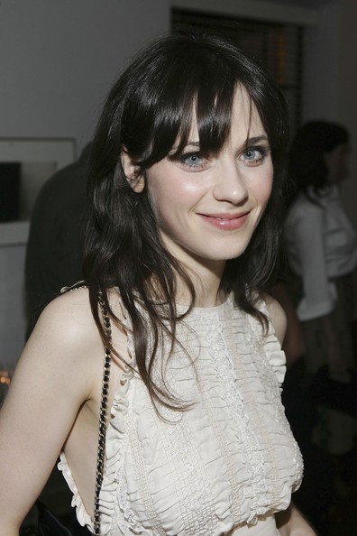 Zooey Deschanel smiles in white ruffles