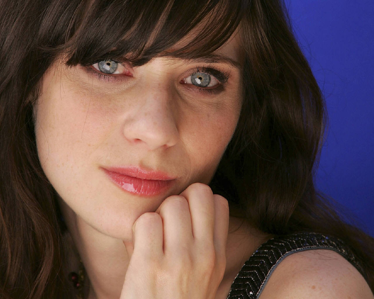Zooey Deschanel looks coy with blue eyes and blue background