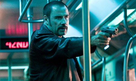 John Travolta prepares to shoot a subway passenger  in The Taking of pellham 1-2-3